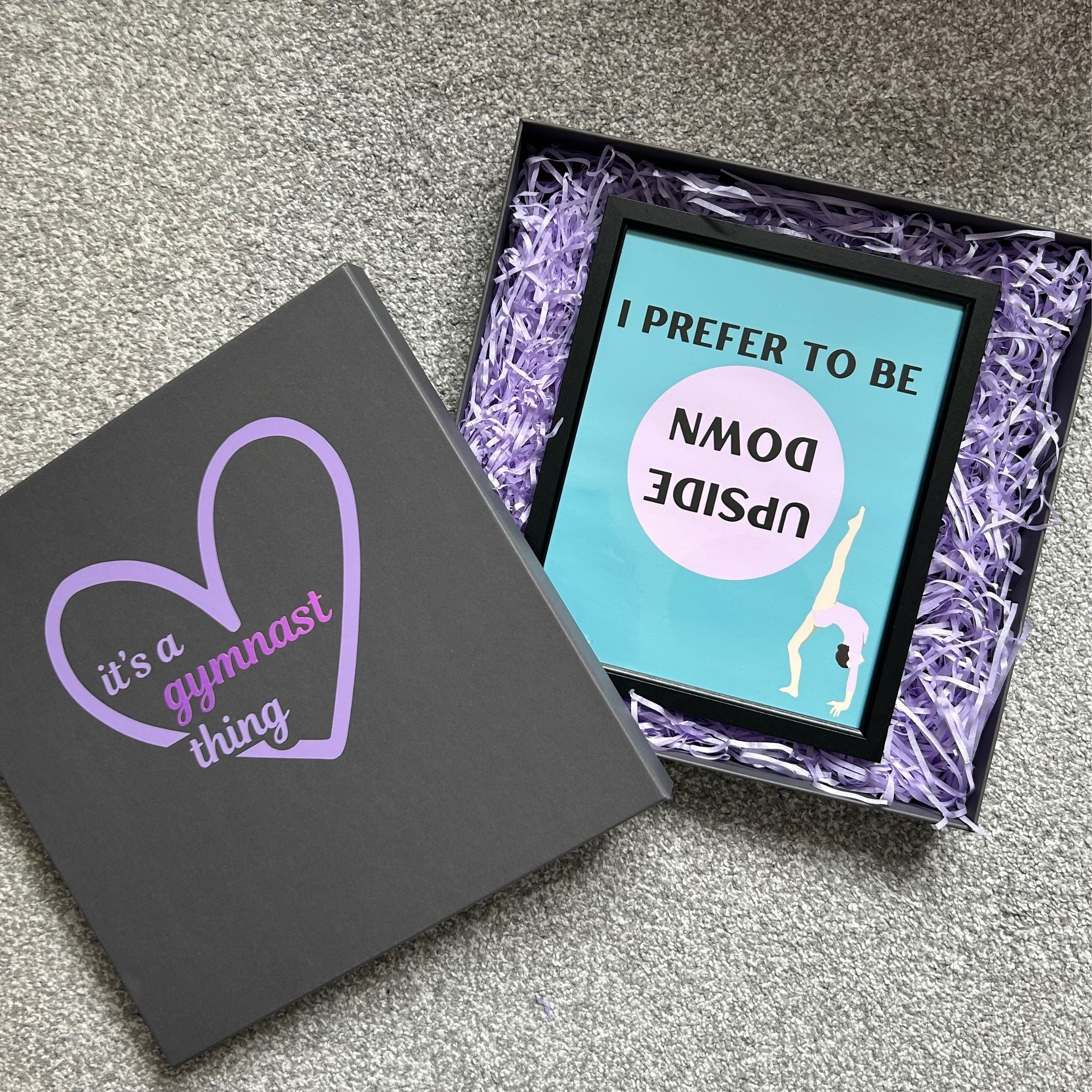 Open gymnastics gift box with a framed picture inside.