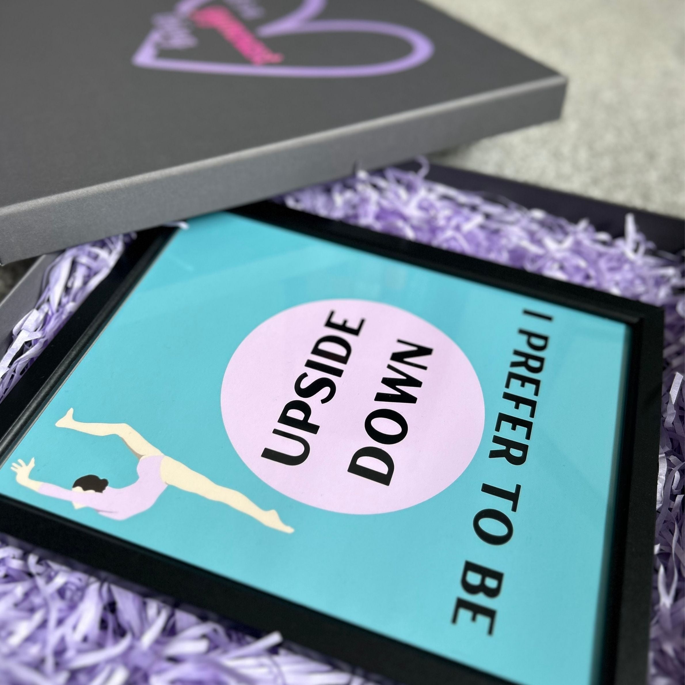 Framed gymnastics poster with 'I Prefer to Be Upside Down' text and a graphic of a person on a blue background, surrounded by purple shredded paper.