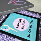Framed gymnastics poster with 'I Prefer to Be Upside Down' text and a graphic of a person on a blue background, surrounded by purple shredded paper.