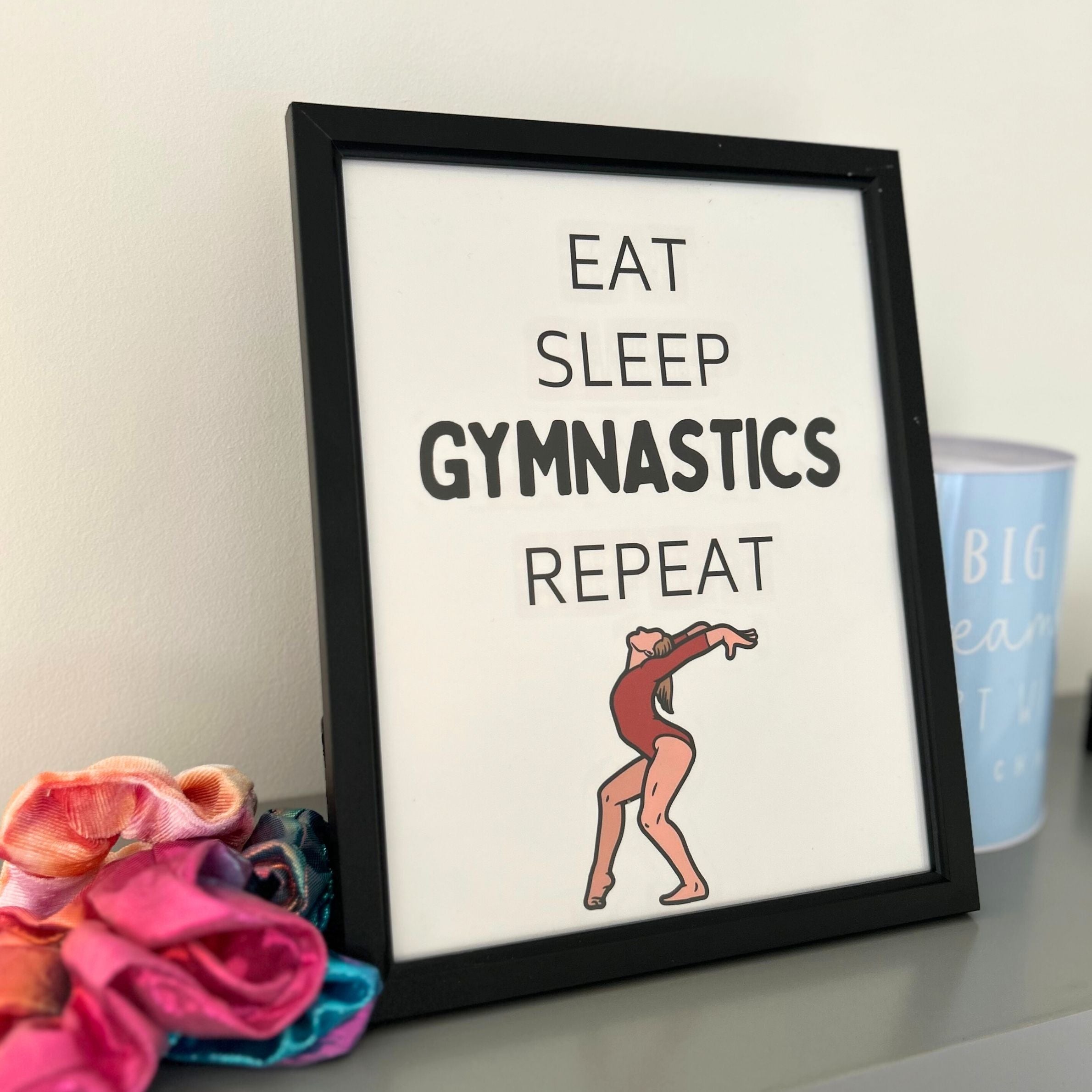 Framed print for gymnasts with 'Eat Sleep Gymnastics Repeat' text and a gymnast illustration on a white background.
