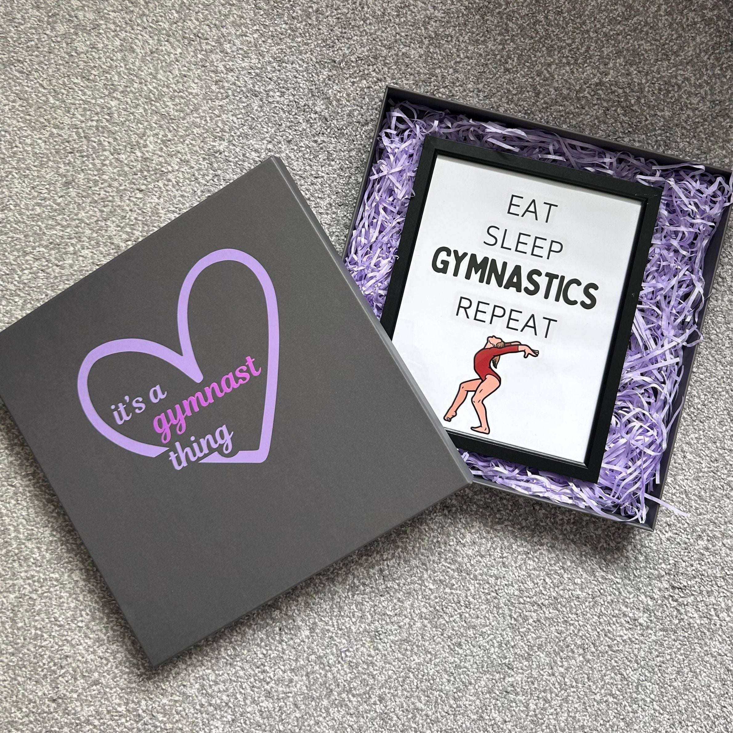 Gymnastics-themed gift box with 'it's a gymnast thing' and 'Eat Sleep Gymnastics Repeat' framed gymnastics print.