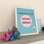 Framed poster for gymnast with text and illustration of a gymnast upside down, next to colourful scrunchies on a surface.