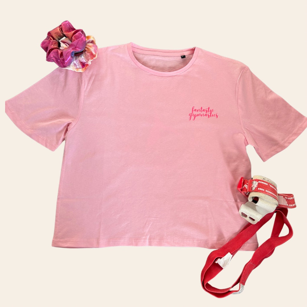 Pink gymnastics t-shirt with 'fantastic gymnastics' logo, scrunchie, handguards and loops on a cream background
