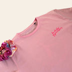 Pink gymnastics t-shirt with 'Fantastic Gymnastics' logo and colourful scrunchie on a beige background
