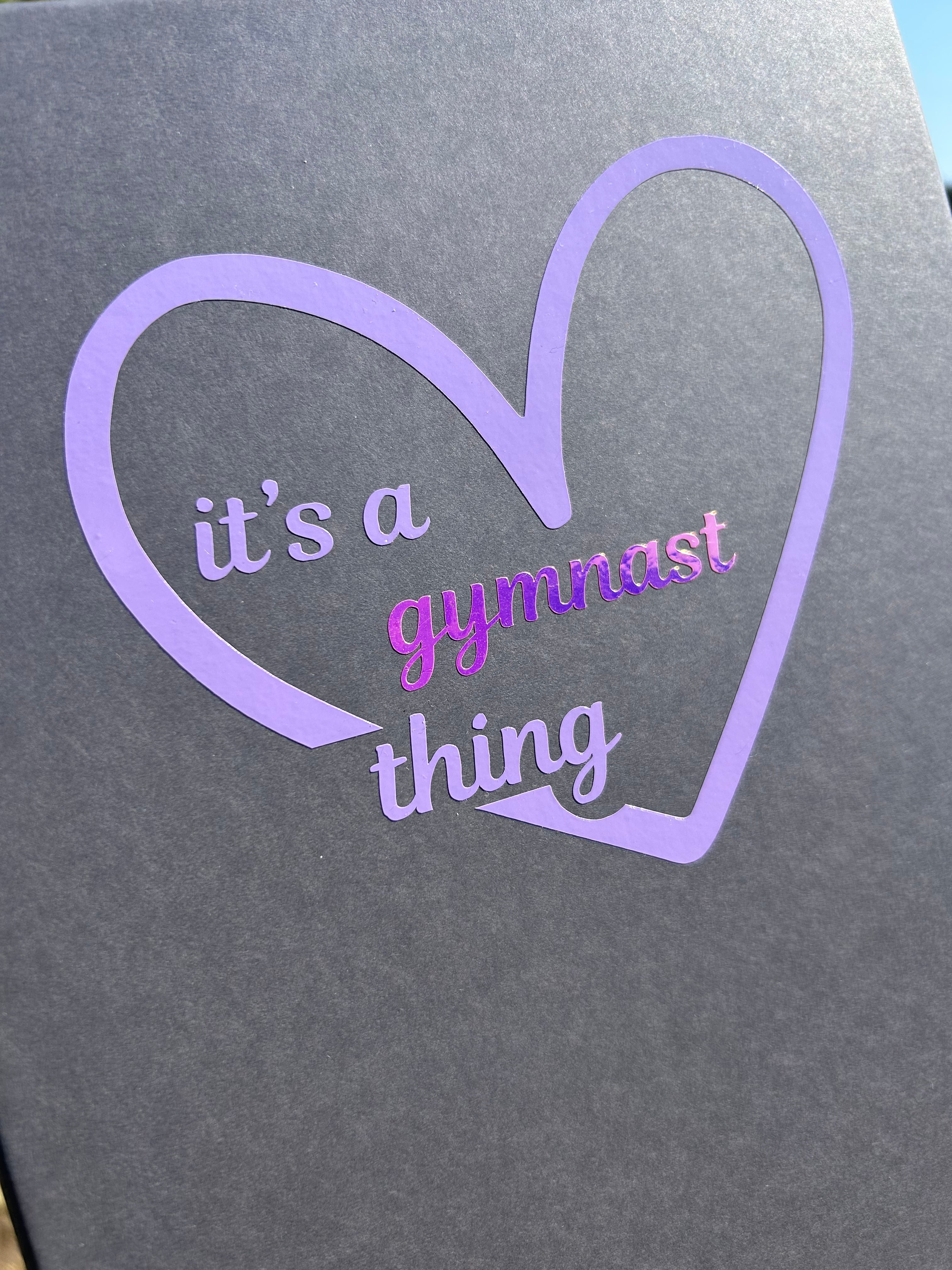 Grey certificate box for gymnasts with a purple heart-shaped design and text 'it's a gymnast thing'.