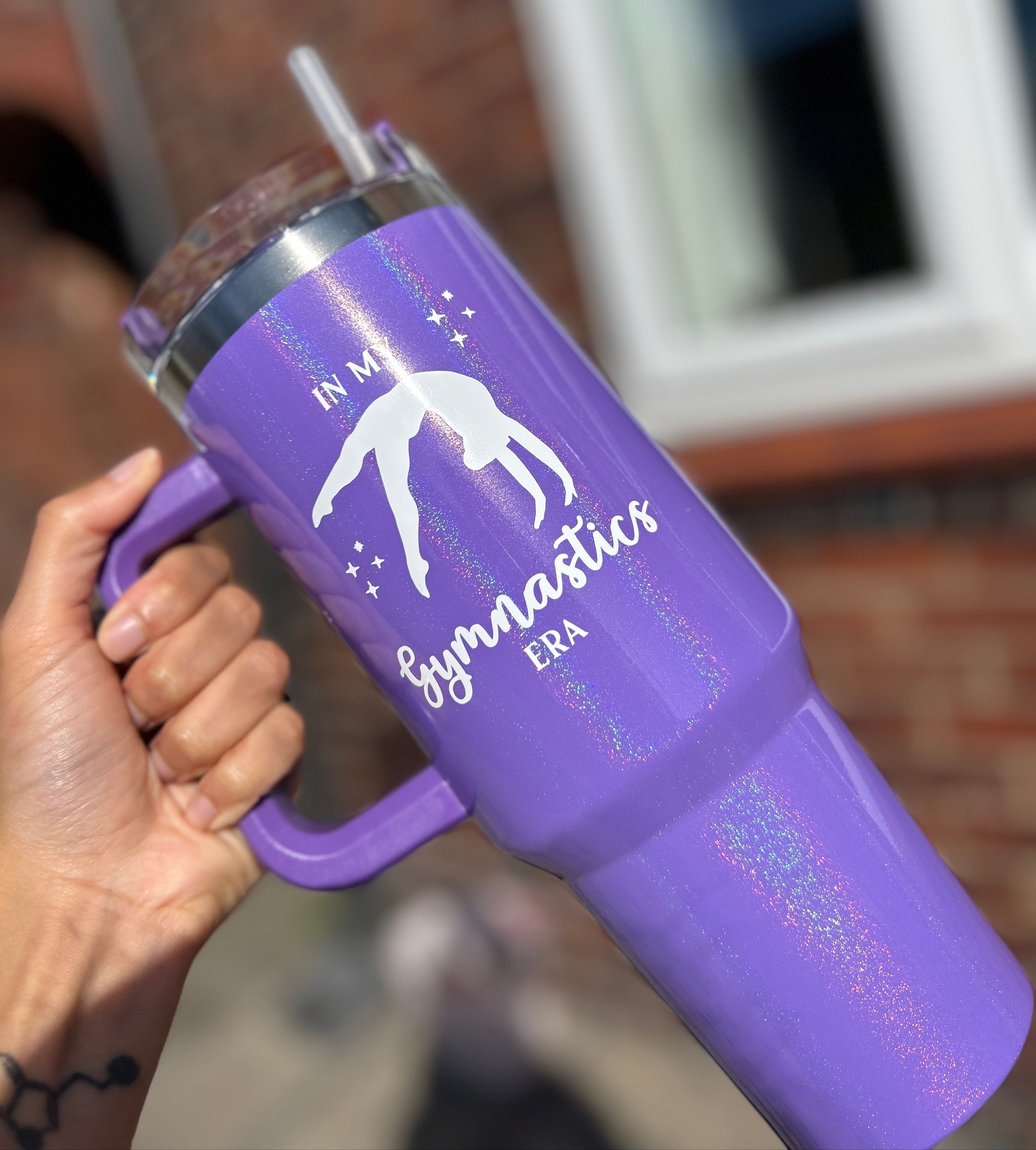 Purple gymnastics 40oz tumbler with 'In My Gymnastics Era' design held by a person outdoors.